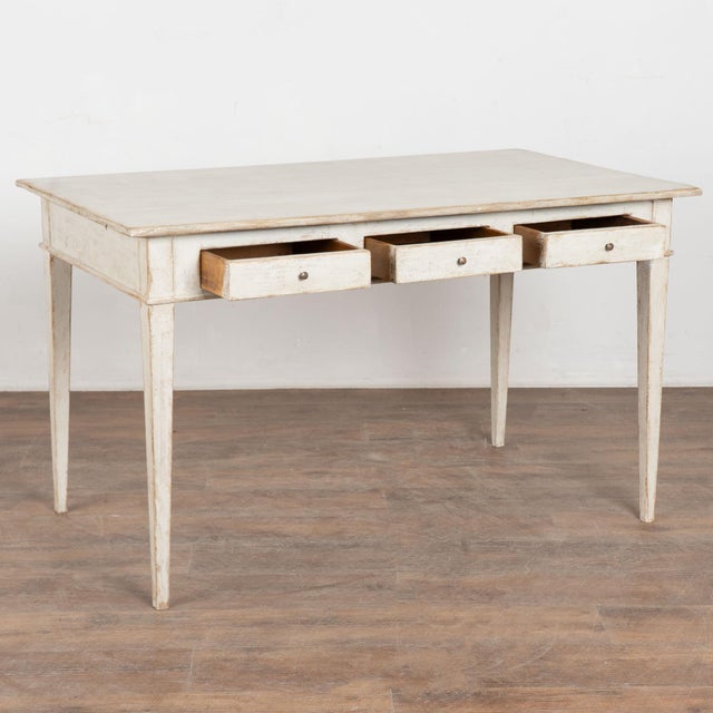 Late 19th century Swedish table crafted in pine and fitted with three small drawers. The table stands on long tapered legs...