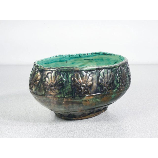 Decorative ceramic bowl painted with glazed finish. The external surface features a relief pattern of shells or stylized...