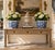 A classic pair of blue and white porcelain planters, rendered in a softly faceted, scalloped form that feels both tailored...