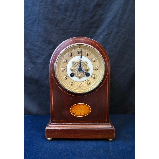 This vintage French mantle clock is designed in polished mahogany wood & dates from the early 20th century. Its bee hive...