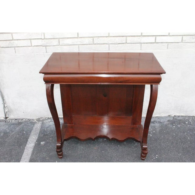 Very elegant Regency style console hallway table made of mahogany featuring a solid rectangular top with a shaped frieze...