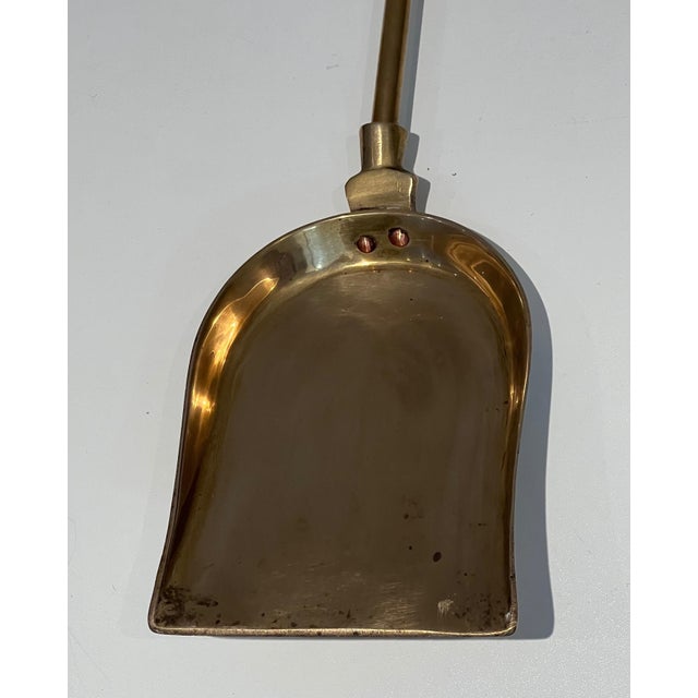 This very elegant neoclassical style fireplace tool is made of brass. This is a French work. Circa 1970