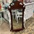 Vintage mahogany wall mirror has an ornate decorative scroll design along both the top and the bottom. The mirror itself...