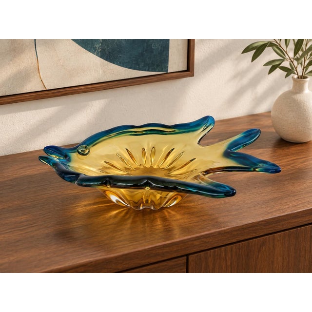 A striking vintage art glass bowl designed in the form of a stylized fish. The piece features a luminous amber-gold body...