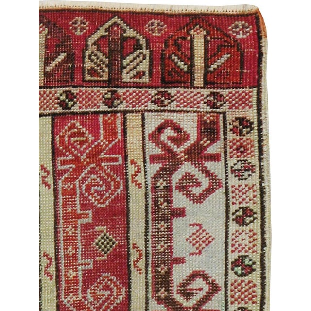 This Early 20th century Turkish Ghiordes rug, measuring 1' 11" x 3' 2", presents a striking example of the Anatolian...