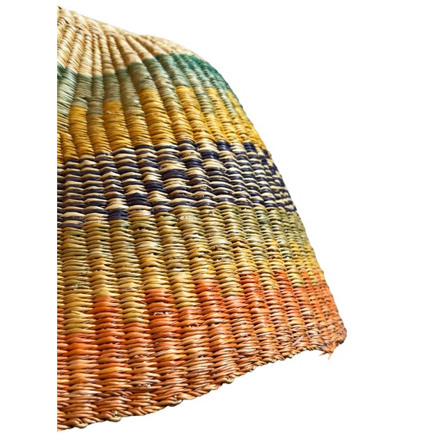 This pendant light began as a traditional Bolga basket from northern Ghana. These baskets were objects of daily use, woven...