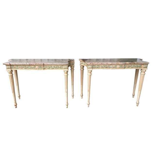 Each with brownish marble tops with laurel leaf carved frieze with gilded details raised on circular tapered fluted legs....
