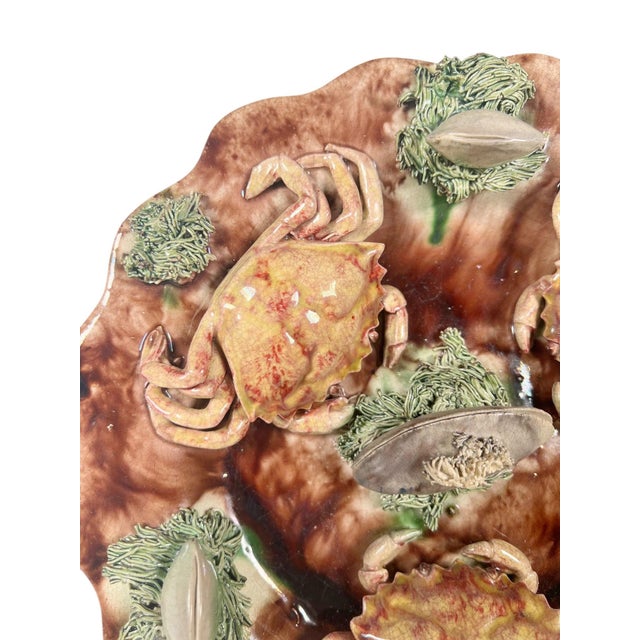 Rare antique Portuguese Cunha Palissy plate featuring a scalloped rim and richly molded decoration of three crabs and...