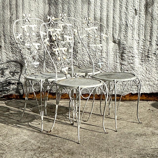 Bring whimsical charm to your dining space with this set of four vintage boho wrought iron strawberry patch dining chairs....