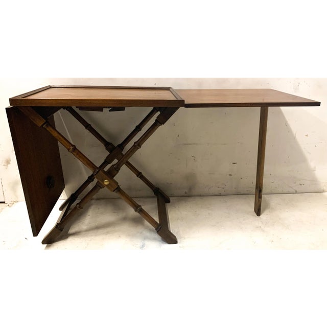This is a regency style faux bamboo folding serving table possibly manufactured by Baker Furniture. It dates to the 70s...