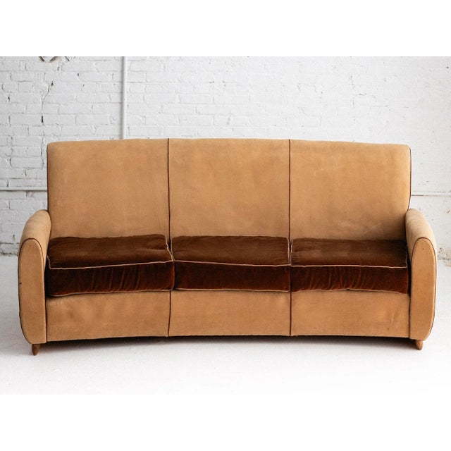 An art deco sofa attributed to Gugliemo Ulrich. Rounded back and aviator style silhouette with wood plinth feet....