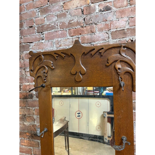 This is an antique hall tree, also known as a hall stand or coat tree, made of oak wood. The piece is characterized by its...