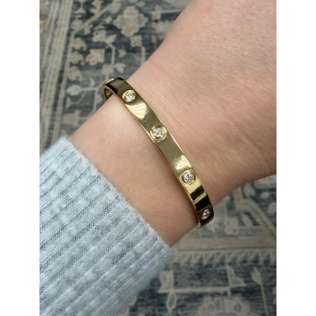 This classic bracelet by Cartier in their iconic LOVE Collection contains ten round brilliant cut diamonds weighing 0.96...