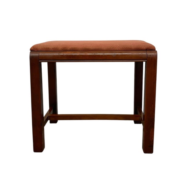 Vintage mid century modern bench stool featuring a solid wood frame with a warm brown finish and an upholstered seat. The...