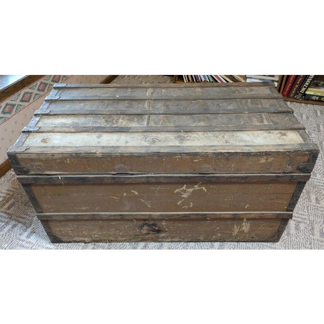 A large, antique Louis Vuitton steamer trunk, likely dating to the early-to-mid 20th century (1900–1950). This substantial...