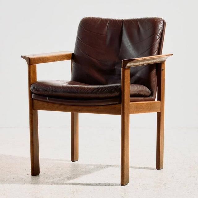 The oak armchair was designed by Laszlo Mazák for Wiesner-Hager in the 1970s. The chair is upholstered with real leather...