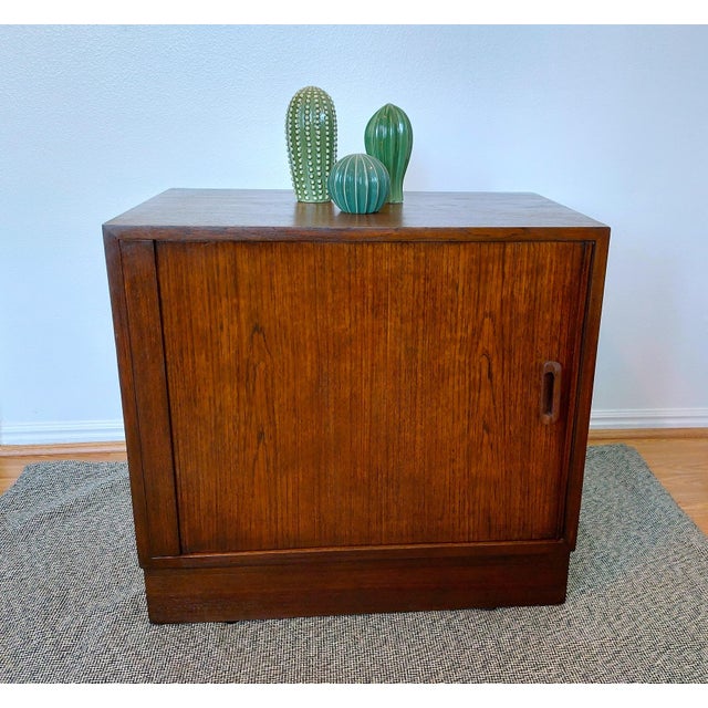 Bring home an authentic piece of Danish Modern design with this beautifully crafted vintage rosewood sliding door cabinet...