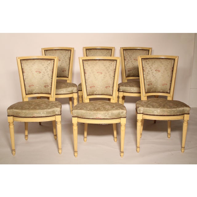 Set of 6 Louis XVI Style painted dining room chairs, circa mid 20th century. With a concave crest rail, a trapezoidal...