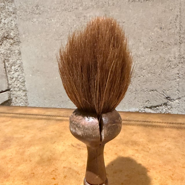 For your consideration, a vintage or antique shaving brush, likely featuring a turned wood handle and natural bristles,...