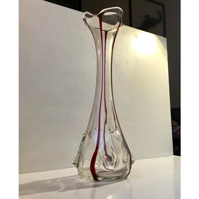 A large (Height: 41 cm) hand blown art nouveau vase. It features cherry glass threading and a ruffled edge. It was made in...