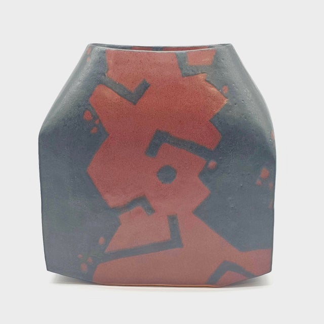 A vessel quiet with intellect, its form deliberate, the sides bowed in soft defiance of symmetry. Slashes of rust and coal...