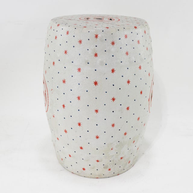 This vintage Chinese ceramic garden stool features a striking red coin motif with pierced detailing, set against a...