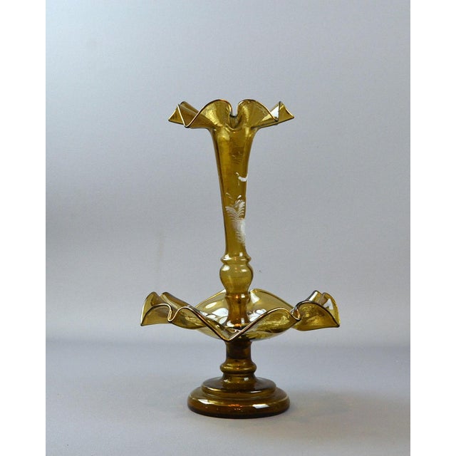 Amber-colored glass flower dish with a flute, handmade by Mary Gregory glass, refers to a type of decorative glass popular...