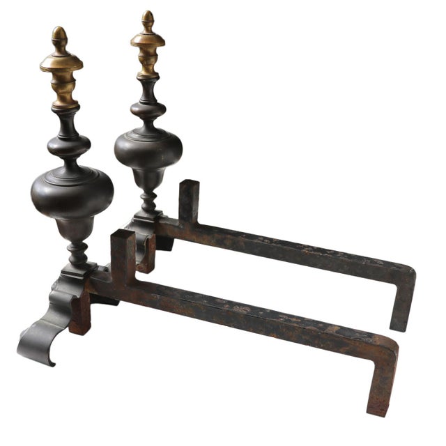 A pair of late 19th-century fireplace andirons in the Renaissance Revival style. Crafted from heavy cast iron and bronze,...