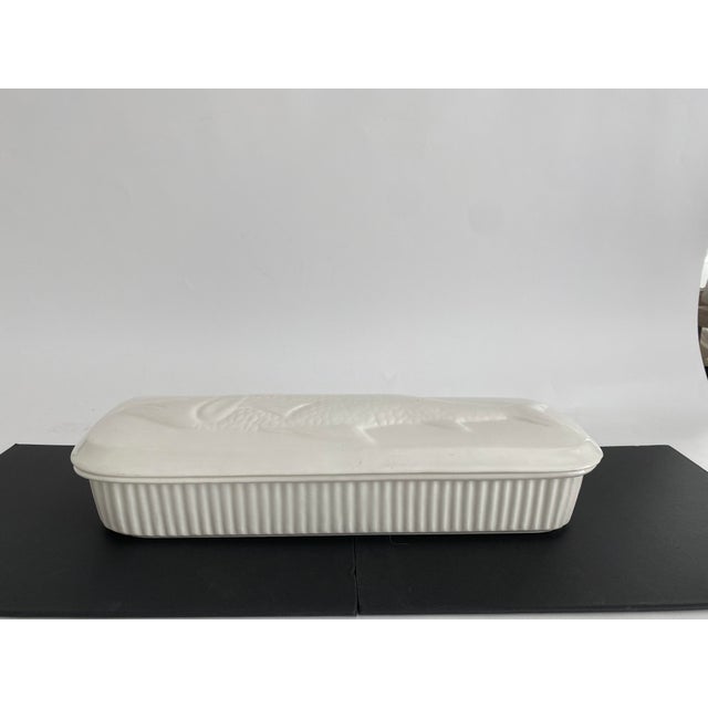 Vintage large white ceramic casserole with lid featuring a finely detailed embossed fish design by El Camino Pottery, USA....