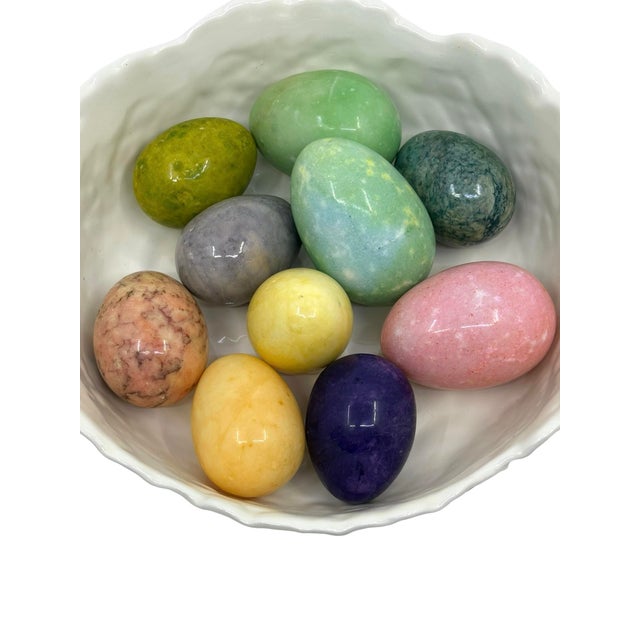 10 colorful hand carved alabaster eggs. Different colors and sizes adorn this cabbage leaf bowl. Some eggs have stickers...