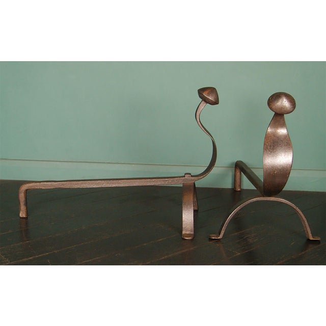 A large pair of wrought-iron swan-neck andirons / fire dogs. The swan-necks are set on arch-supports with iron-rivet. A...