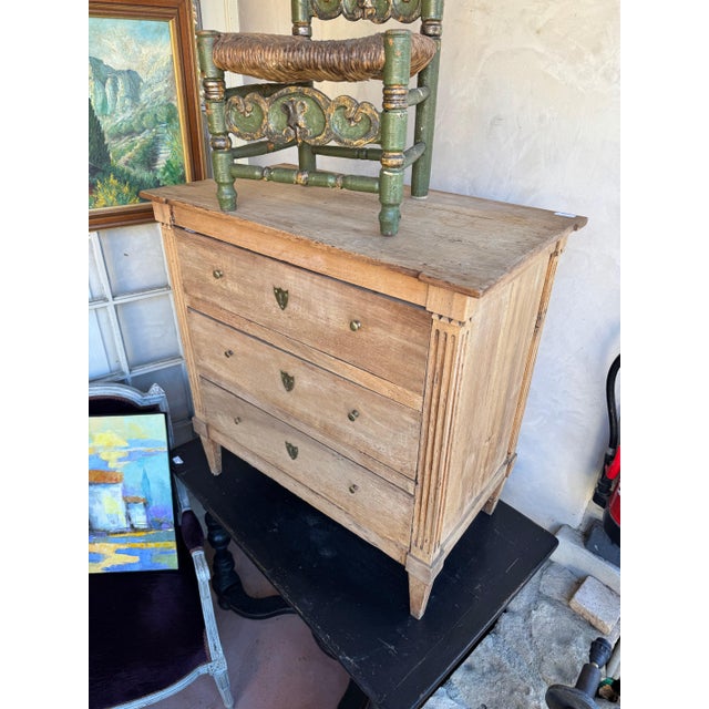French 19th c Louis XVI style bleached commode. Reese’s sides with three paneled drawers. Original brass hardware 32”l x...