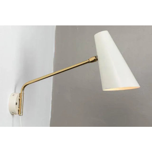 1960s Cosack Leuchten articulating wall light. Executed in white enameled metal and brass in the manner highly reminiscent...