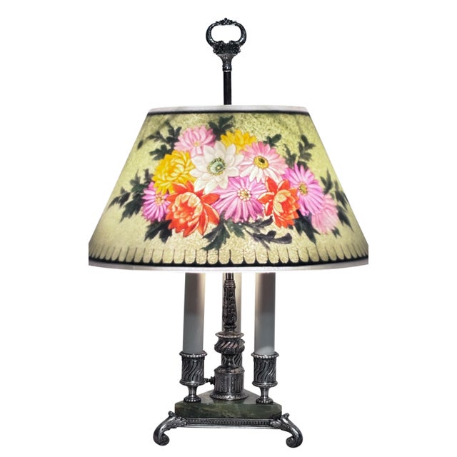 A Pairpoint reverse painted glass table lamp, dated circa 1915 - 1920, showcases a cheerful floral design shade on a green...