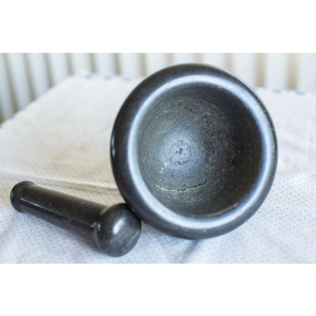 A Medium-size Black Marble Grinding Stone Mortar and Pestle Set. Smooth honed surface on the outside, slightly rough on...