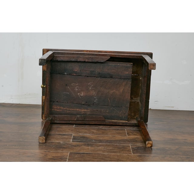An English oak side table from the 19th century with rectangular planked top, single drawer and straight legs. This...