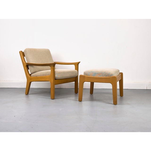 High-quality lounge chair made of solid oak with matching footstool. Spring core cushions upholstered in a textured beige...