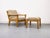 High-quality lounge chair made of solid oak with matching footstool. Spring core cushions upholstered in a textured beige...
