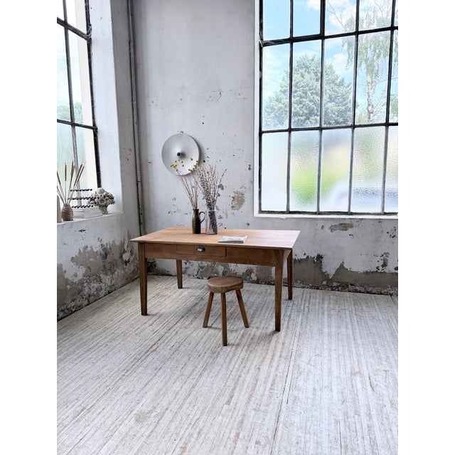 Vintage 1950s cherry wood farmhouse table with tapered legs. we love its clean lines, with its compact size yet pleasing...