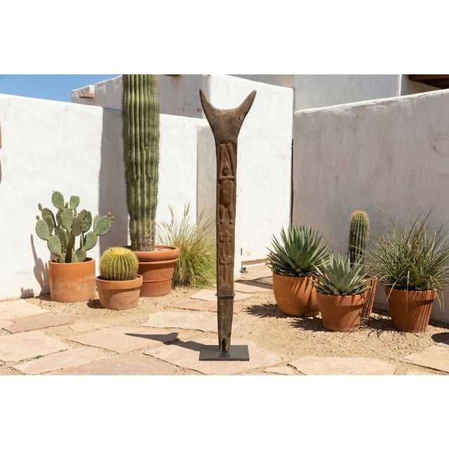 This Bamileke house post, with its stylized human figure and subtly carved crocodile, offers a glimpse into the rich...