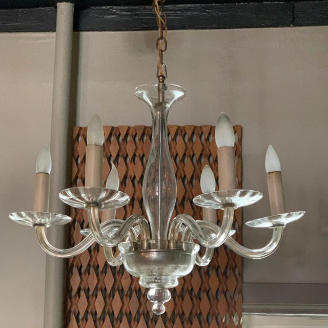 Italian, midcentury, clear Murano glass chandelier features 6 stems that can accept medium socket bulbs up to 40 watts...