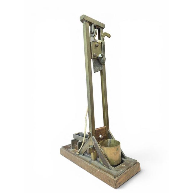 Elegant early 20th-century cigar guillotine cutter crafted in brass and wood, dating from the first half of the 1900s....