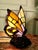 French Glass Tiffany Style Lamp in the form of a Butterfly This charming lamp has a heavy metal base decorated with Roses,...