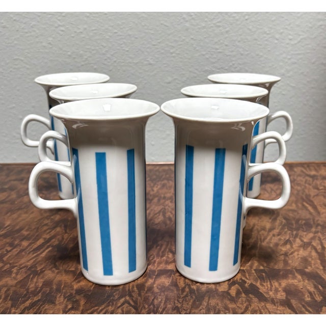 Here's a fab, fun set of white-and-cerulean mugs and snack saucers designed by noted mid-century ceramicist LaGardo...