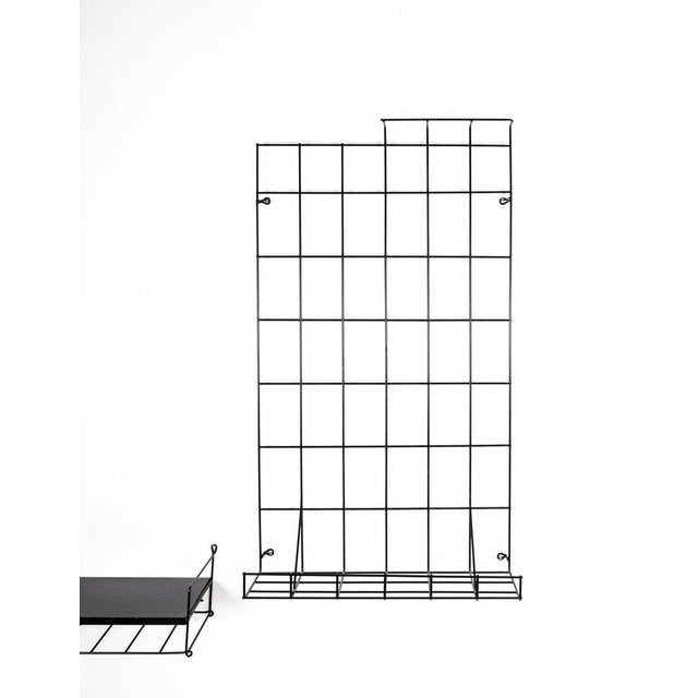 Design from the middle of the century minimalist in the hallway for lovers of simplicity. Black metal wire and a black-...