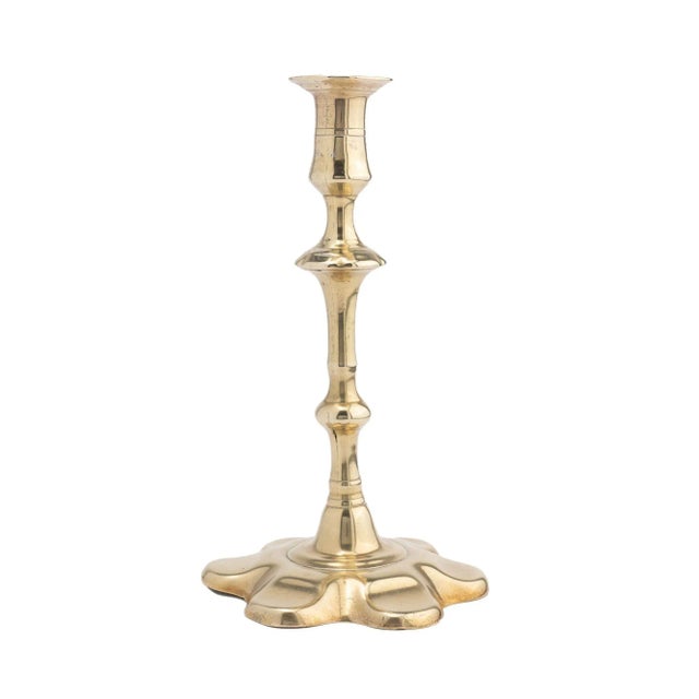 Petal base Queen Anne candlestick in seamed and cast brass. The candle cup incorporates a circular dished bobeshe and a...