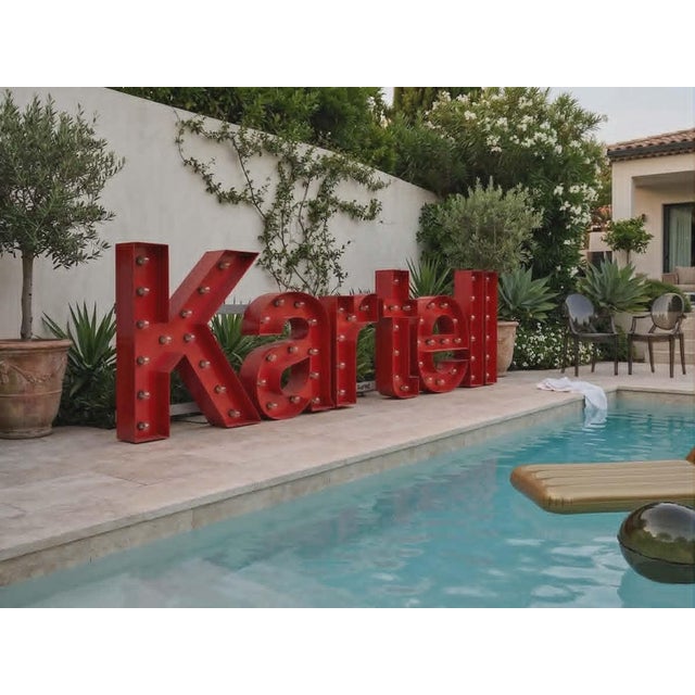 Large, distinctive vintage illuminated sign composed of red lacquered metal letters, each punctuated by exposed bulbs....