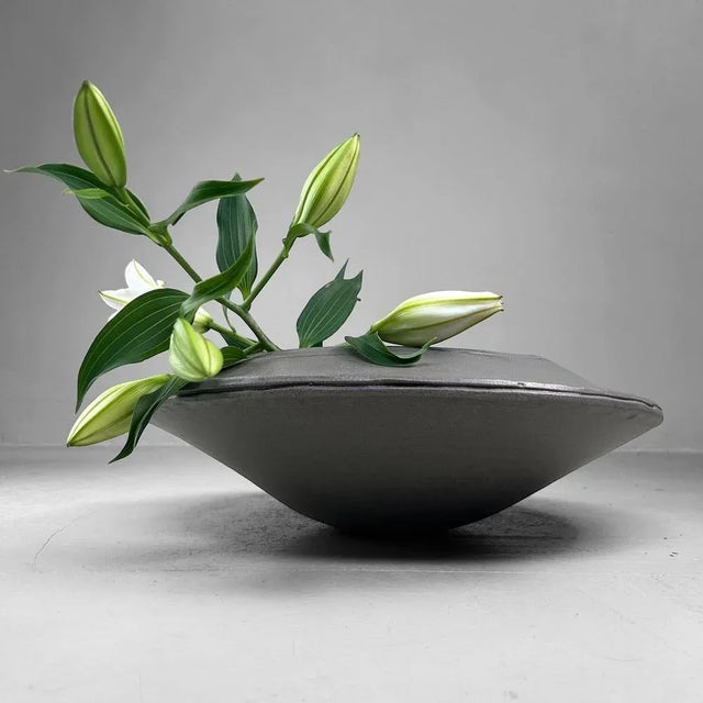 A large ikebana bowl crafted in wood-fired stoneware, produced at a Japanese studio pottery kiln in the 1970s. Dimensions:...