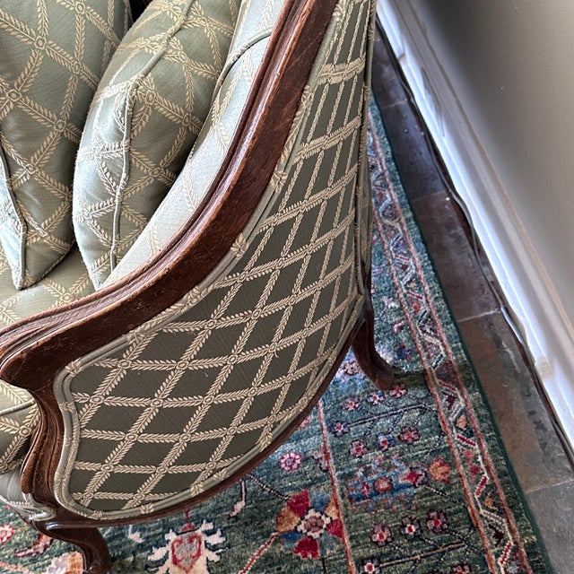 Louis XIV Settee A sweetly scaled settee with a green trellis upholstery and carved Louis wood frame. In very good...