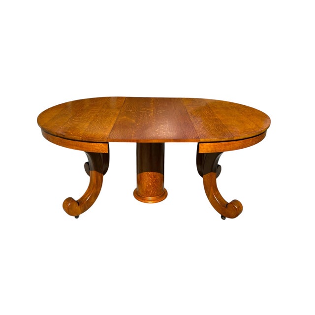 An American Empire extending dining table circa 1900. Made of quarter sawn oak, with a round central pedestal base and...